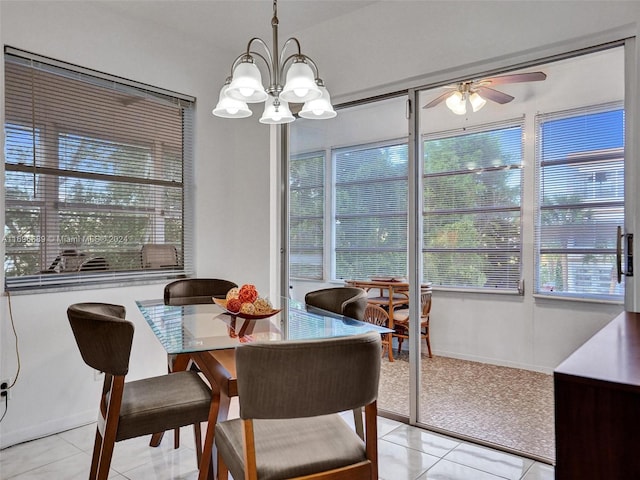 dining space featuring light tile patterned flooring and ceiling fan with notable chandelier