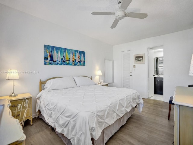 bedroom with a closet, hardwood / wood-style flooring, ensuite bath, and ceiling fan