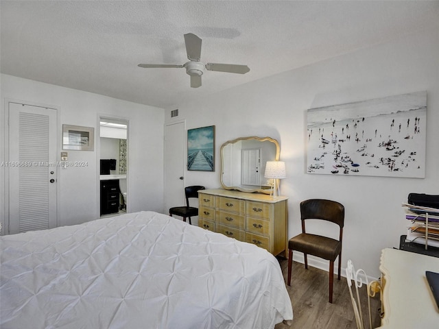 bedroom featuring a textured ceiling, hardwood / wood-style flooring, ceiling fan, and ensuite bathroom