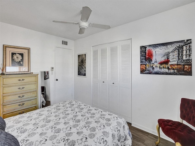 bedroom featuring a textured ceiling, ceiling fan, a closet, and dark hardwood / wood-style floors