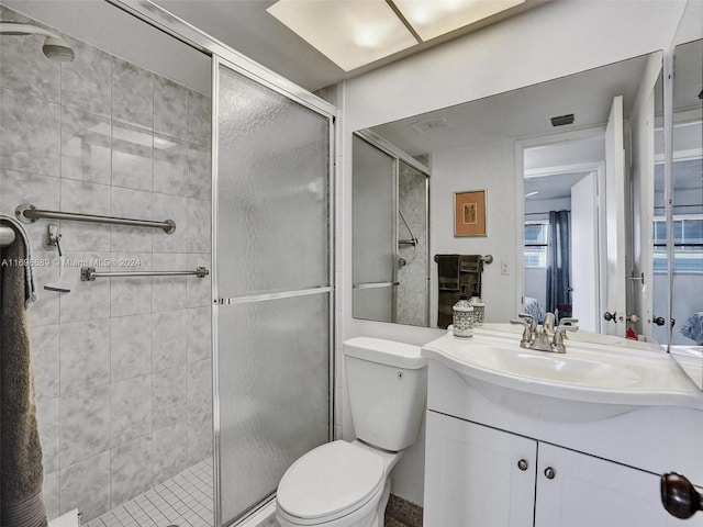 bathroom featuring vanity, toilet, and an enclosed shower