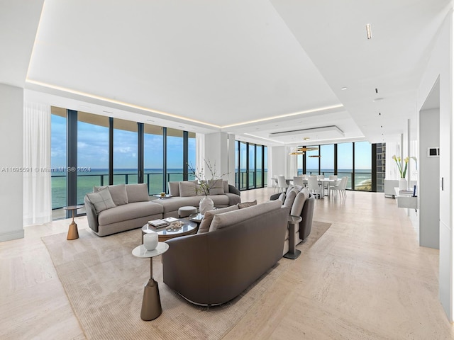 living room with a water view, expansive windows, and light hardwood / wood-style floors