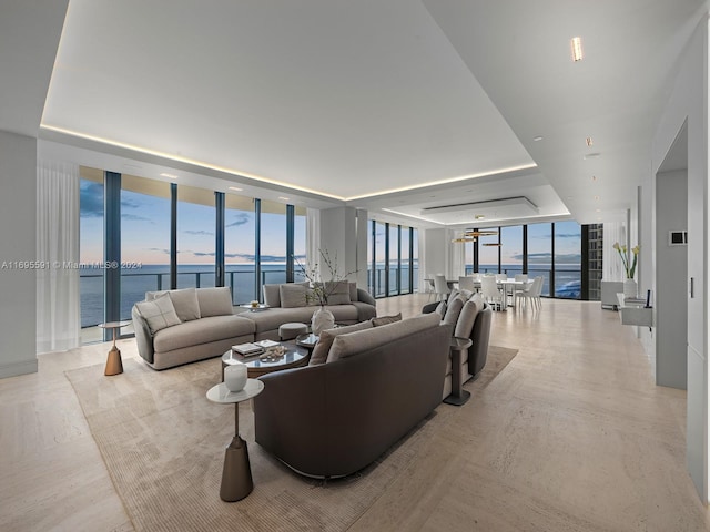 living room featuring expansive windows, a water view, and light hardwood / wood-style floors