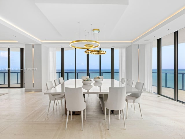 dining room with a wealth of natural light, a water view, and a wall of windows