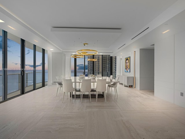 dining space featuring a notable chandelier and a water view