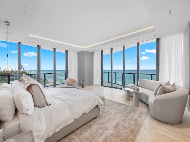 bedroom with a water view, multiple windows, and expansive windows