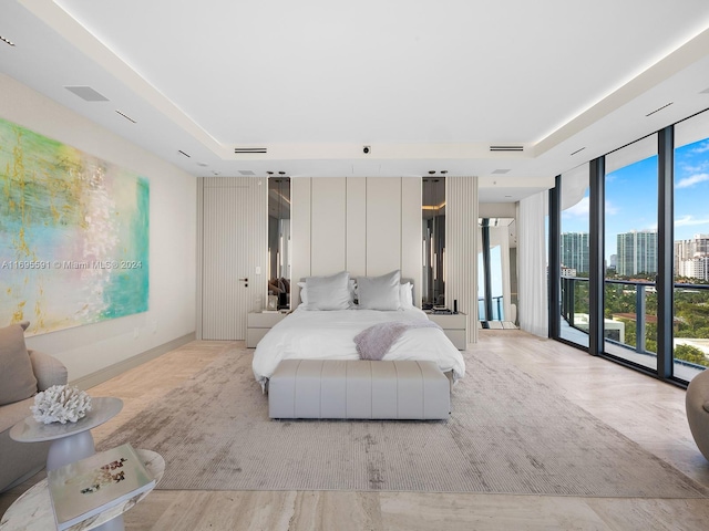 bedroom featuring light wood-type flooring, access to outside, and floor to ceiling windows