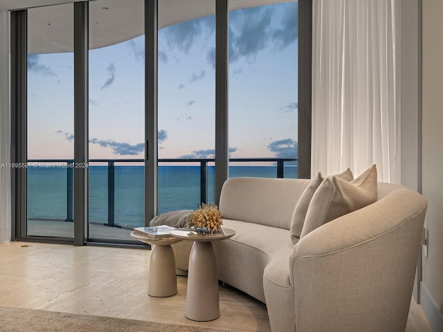 living room featuring floor to ceiling windows and a water view