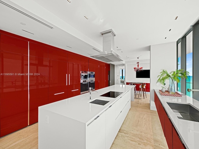 kitchen with island exhaust hood, light wood-type flooring, black electric cooktop, a spacious island, and sink