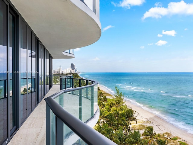 balcony featuring a beach view and a water view