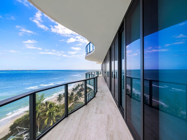 balcony featuring a water view and a view of the beach