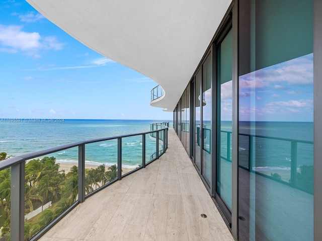 balcony featuring a water view and a view of the beach