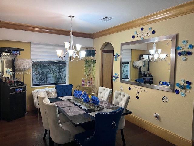 dining area with dark hardwood / wood-style flooring, ornamental molding, and a notable chandelier