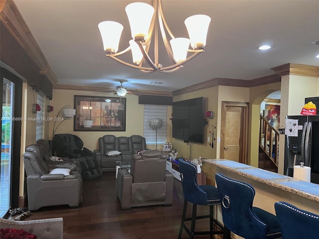 living room featuring crown molding, dark wood-type flooring, and ceiling fan with notable chandelier