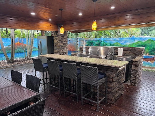 kitchen featuring light stone countertops, dark hardwood / wood-style flooring, hanging light fixtures, and wooden ceiling