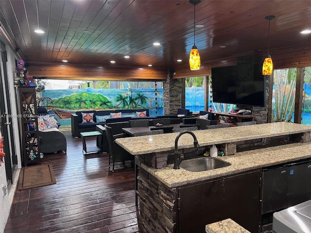 kitchen featuring light stone counters, wood ceiling, dark wood-type flooring, sink, and decorative light fixtures