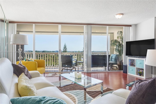 living room with expansive windows, a textured ceiling, and hardwood / wood-style flooring