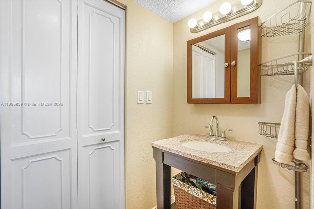 6921 Environ Blvd Unit 8N, Lauderhill, FL 33319 - bathroom featuring vanity, a textured ceiling, and a textured wall