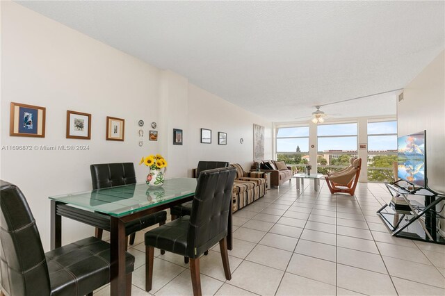 dining space featuring ceiling fan, light tile patterned floors, a textured ceiling, and lofted ceiling