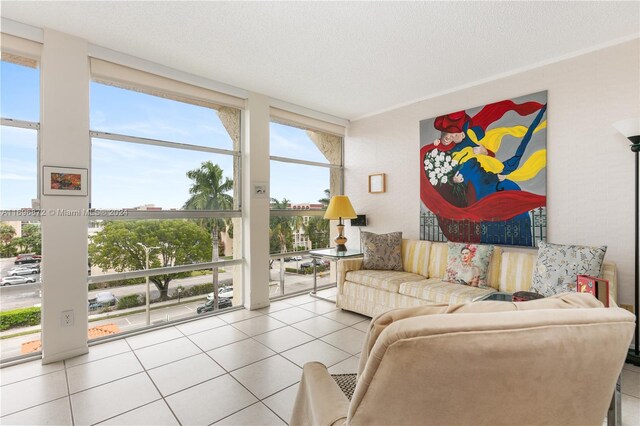 tiled living room featuring expansive windows, a healthy amount of sunlight, and a textured ceiling