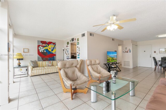 tiled living room featuring ceiling fan and a textured ceiling