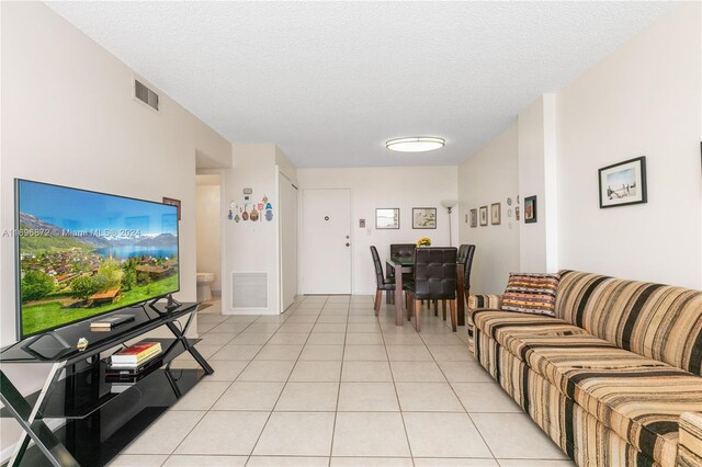 living room with light tile patterned flooring and a textured ceiling