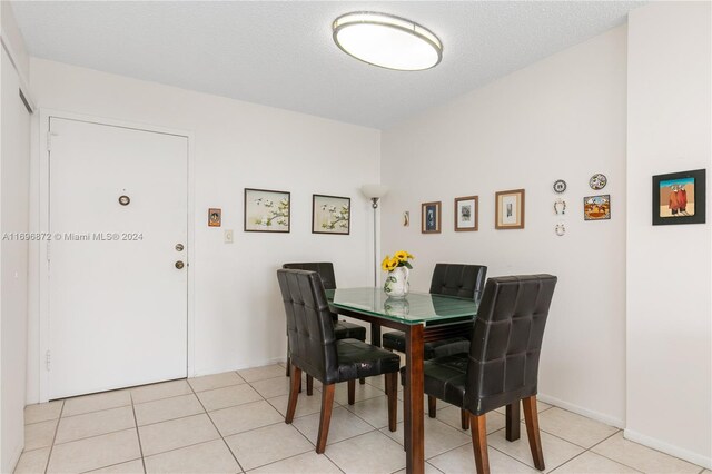 tiled dining area featuring a textured ceiling