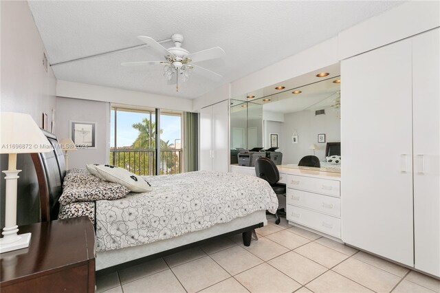 tiled bedroom with ceiling fan and a textured ceiling