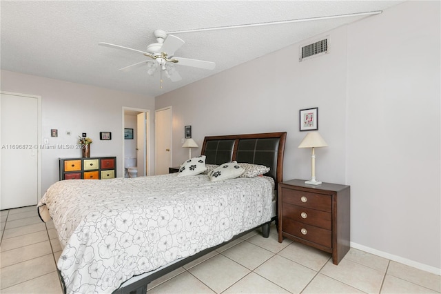 tiled bedroom with ceiling fan and a textured ceiling