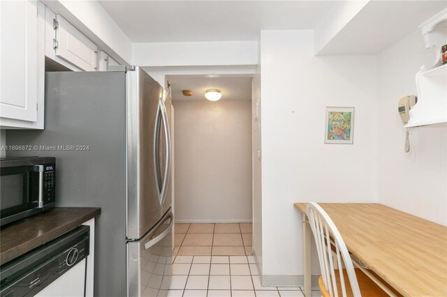 kitchen with white cabinetry, light tile patterned floors, and appliances with stainless steel finishes