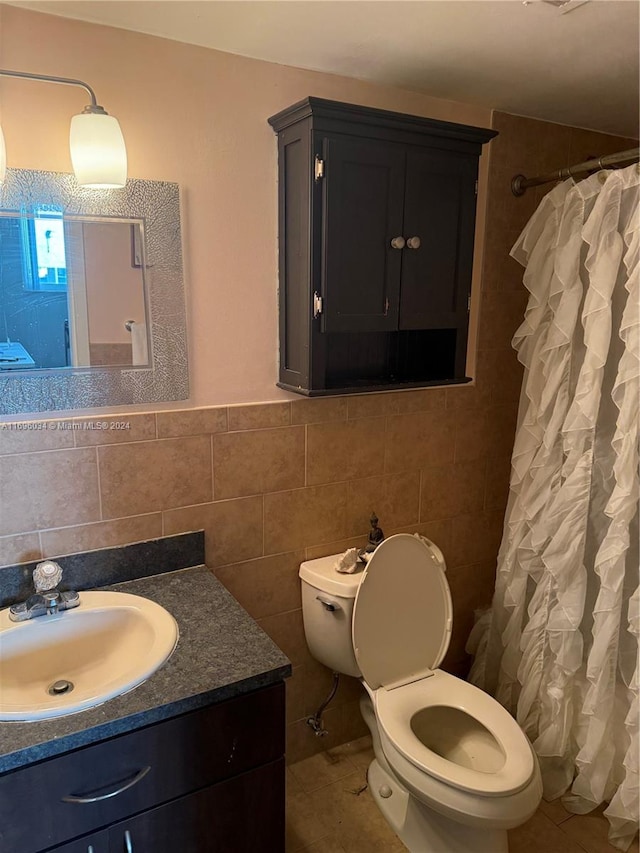 bathroom featuring tile patterned flooring, vanity, toilet, and tile walls