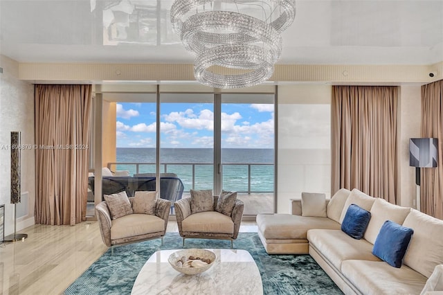 living room featuring hardwood / wood-style floors, a water view, a chandelier, and a wall of windows