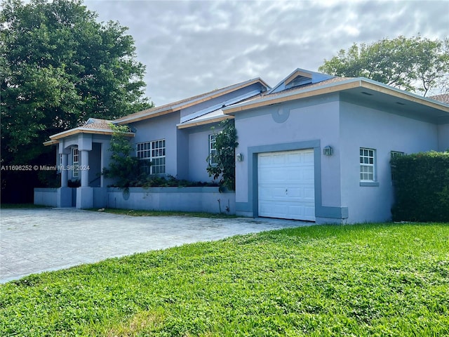 ranch-style home with a garage and a front lawn