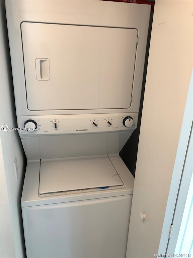 washroom featuring stacked washer and clothes dryer