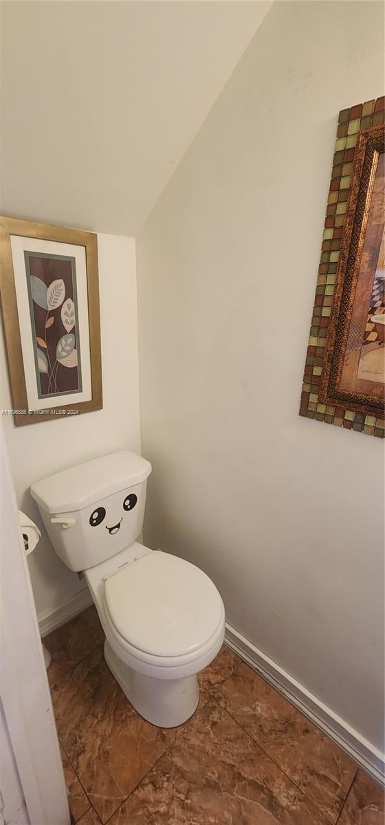 bathroom with vaulted ceiling and toilet