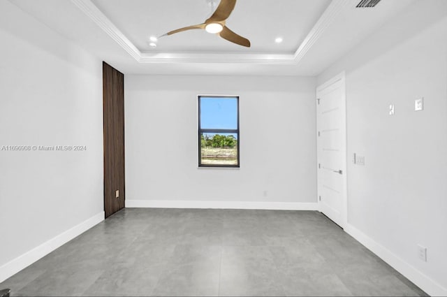 spare room with ceiling fan, a raised ceiling, and ornamental molding