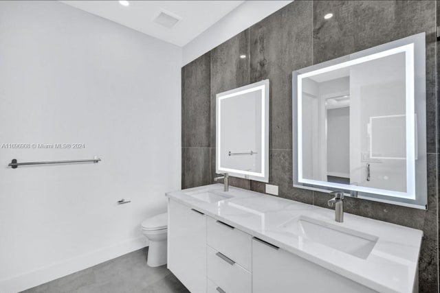 bathroom featuring vanity, toilet, and tile walls