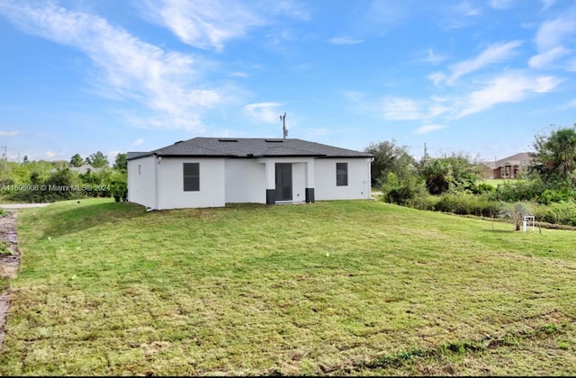 rear view of house featuring a lawn