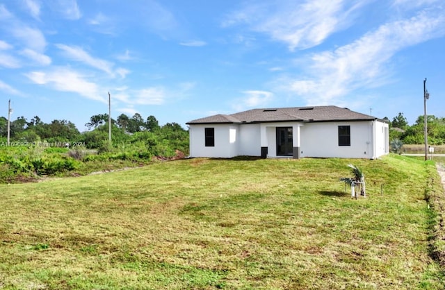 rear view of property featuring a yard