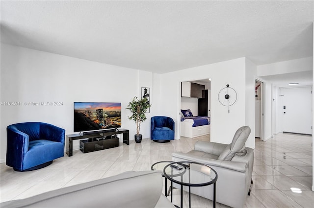 tiled living room featuring a textured ceiling