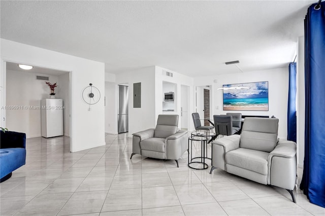 living room with light tile patterned floors, a textured ceiling, and electric panel