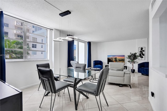 tiled dining space with a textured ceiling and a healthy amount of sunlight