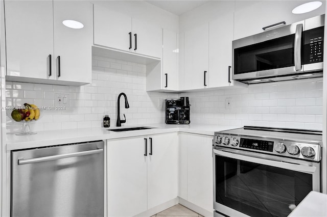 kitchen with white cabinets, decorative backsplash, sink, and appliances with stainless steel finishes