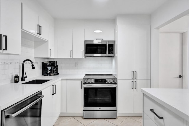 kitchen featuring stainless steel appliances, white cabinetry, and sink