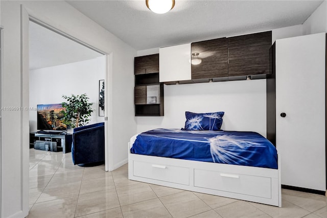 bedroom with light tile patterned floors and a textured ceiling