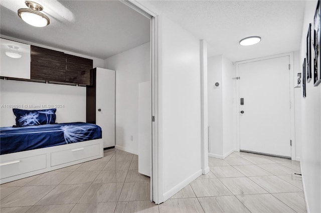 bedroom with light tile patterned floors and a textured ceiling