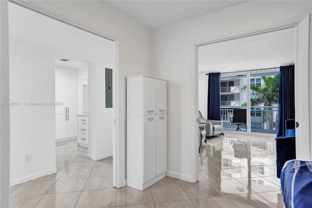 hallway with light tile patterned floors and electric panel