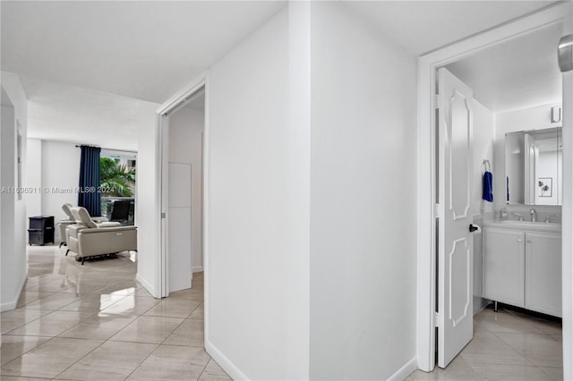 corridor with sink and light tile patterned floors