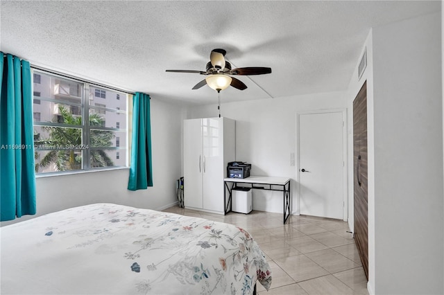 tiled bedroom featuring ceiling fan and a textured ceiling