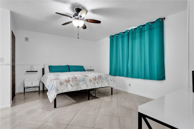 tiled bedroom featuring ceiling fan and a textured ceiling